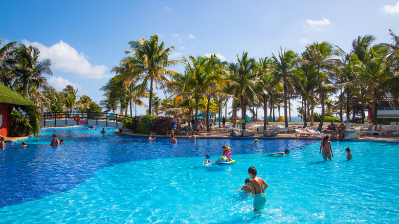 Grand Oasis hotel swimming pool with people and kids playing in the water.
