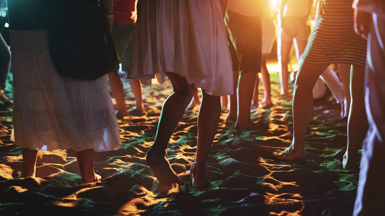 Legs of people partying on beach